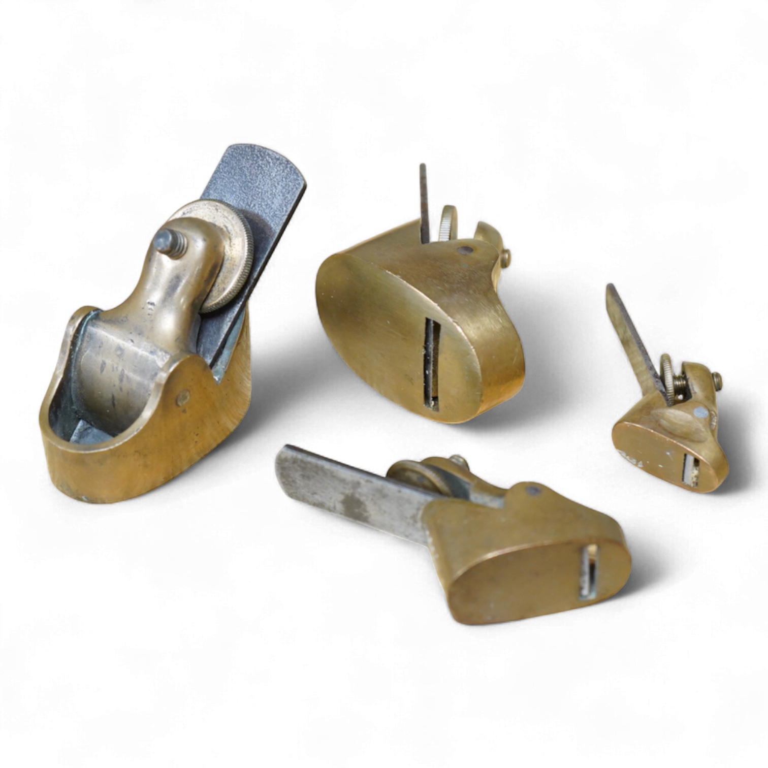 A group of four gunmetal violin planes, three with flat soles, one with rounded sole, all unmarked but all with Preston irons, largest 2 1/8”, smallest 1”